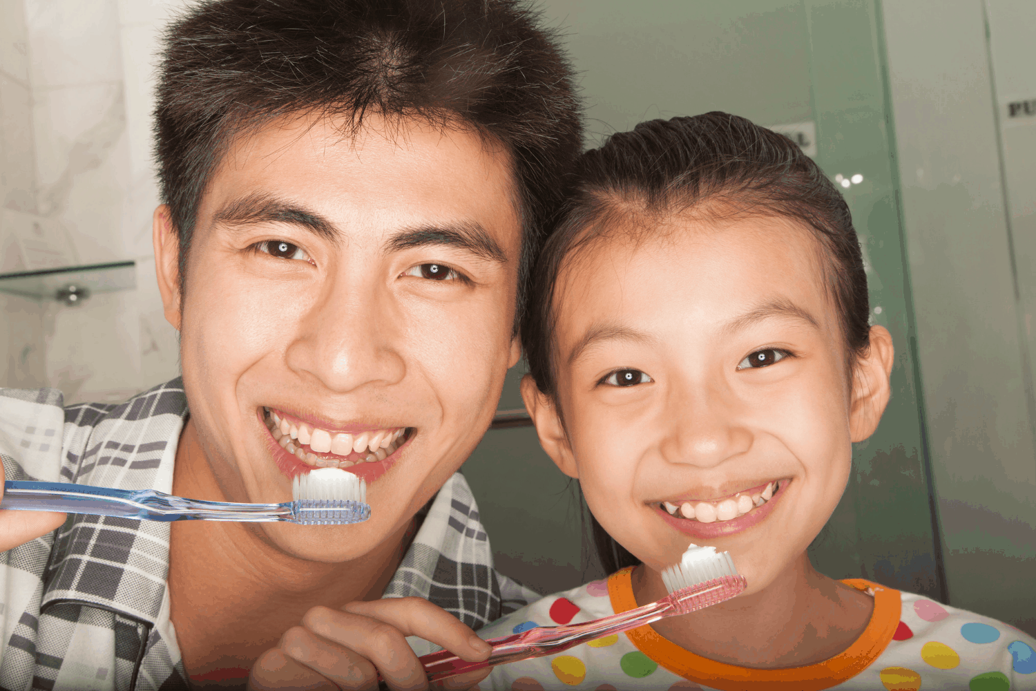 father and daughter brushing teeth